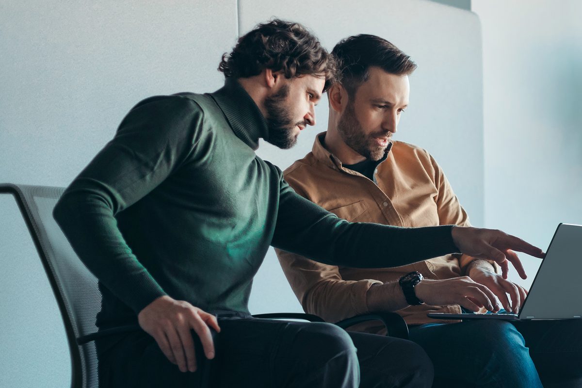 Two developers reviewing a build together at a laptop